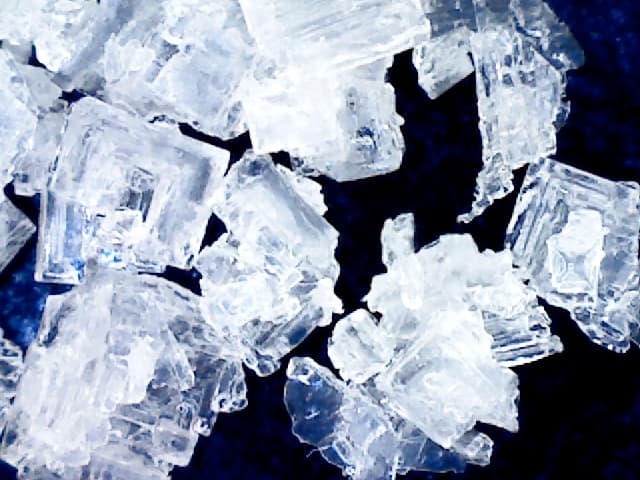 Hard uniform crystals of a high sodium chloride/low moisture sea salt